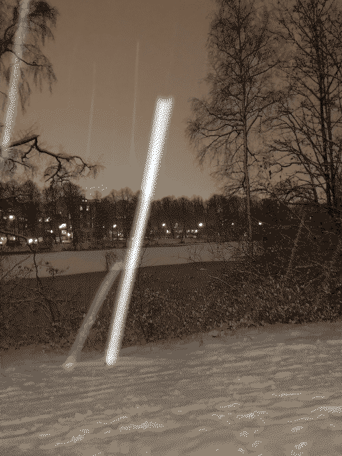 A snowy landscape in twilight. Big snowflakes are traversing the image like shooting stars.